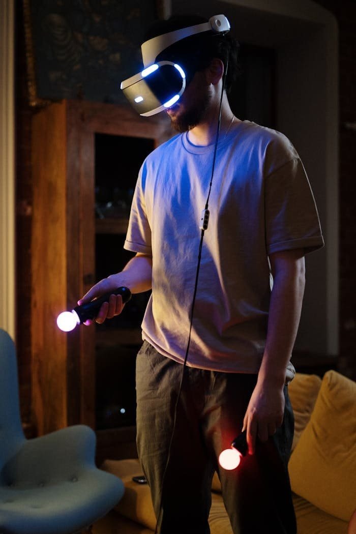A young man immersed in virtual reality gaming in a cozy home setting at night.